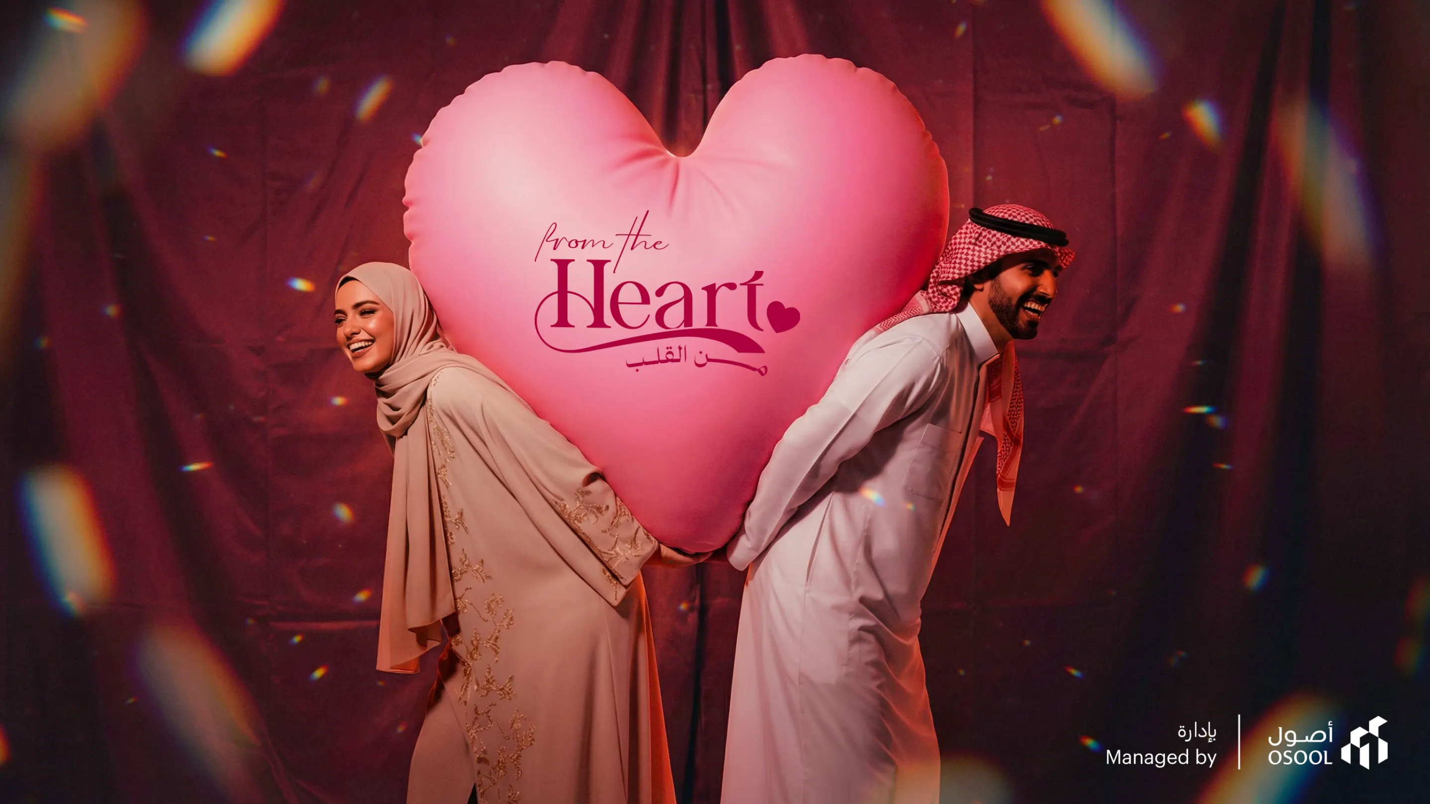 From the Heart key visual: a man and a woman holding a giant pink heart between them