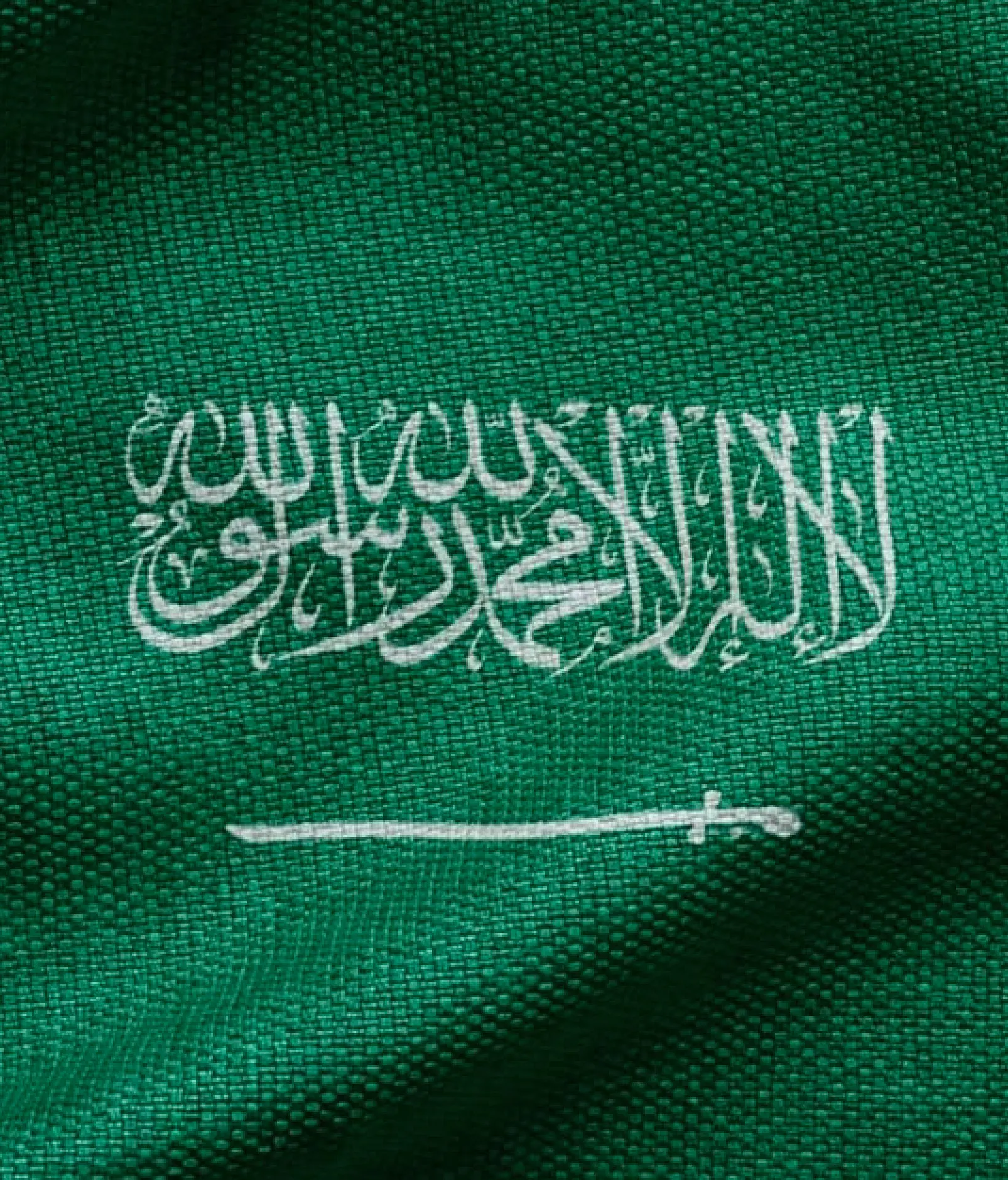 Close up of the Saudi flag’s green fabric and calligraphy