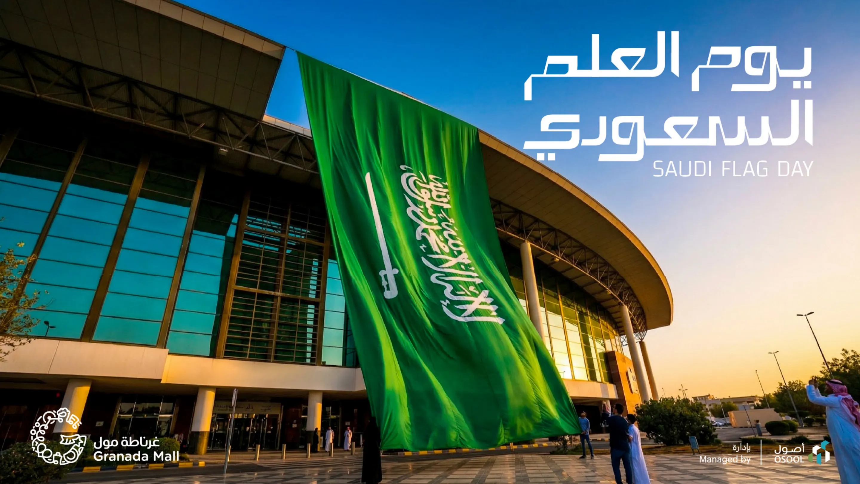 Saudi Flag Day key visual for Granada Mall: a giant Saudi flag hanging over the mall entrance at sunset