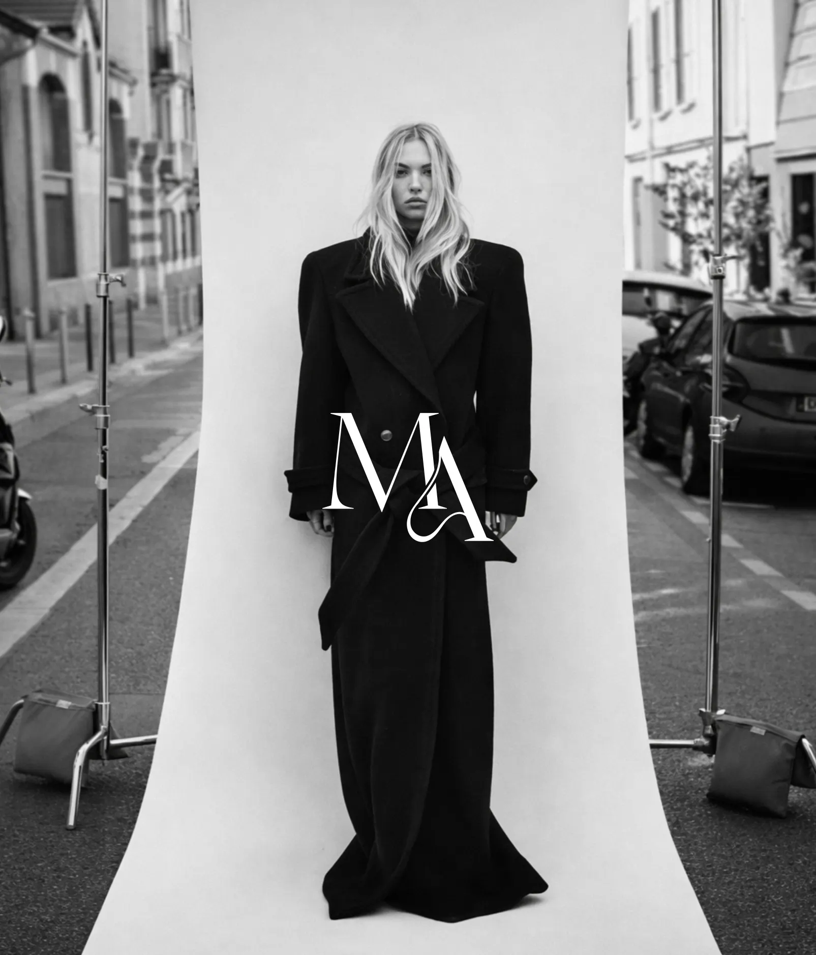 A model in a black suit with the Meraki monogram